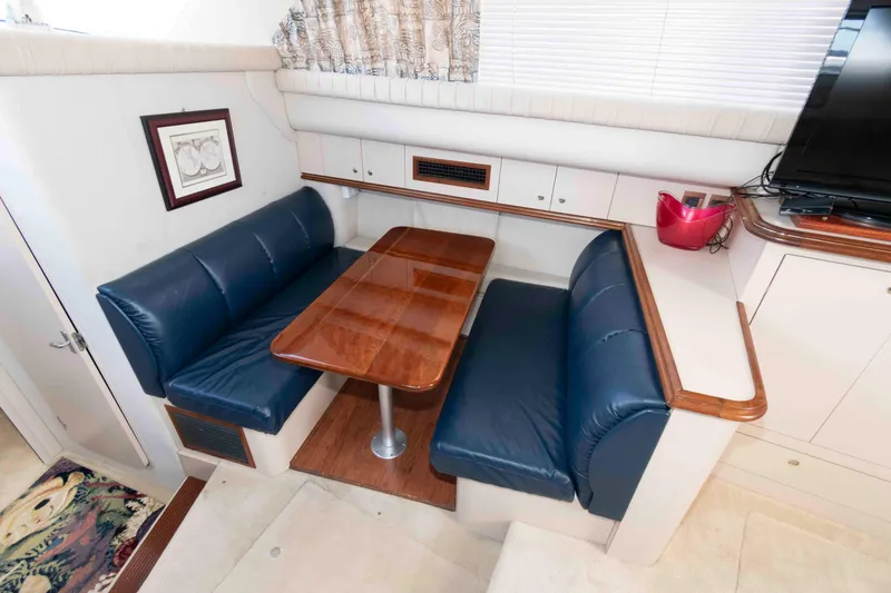 Slide: The Image of 1999 Cruisers Yachts 3750 Motoryacht interior with blue leather seating and wooden table. - 13