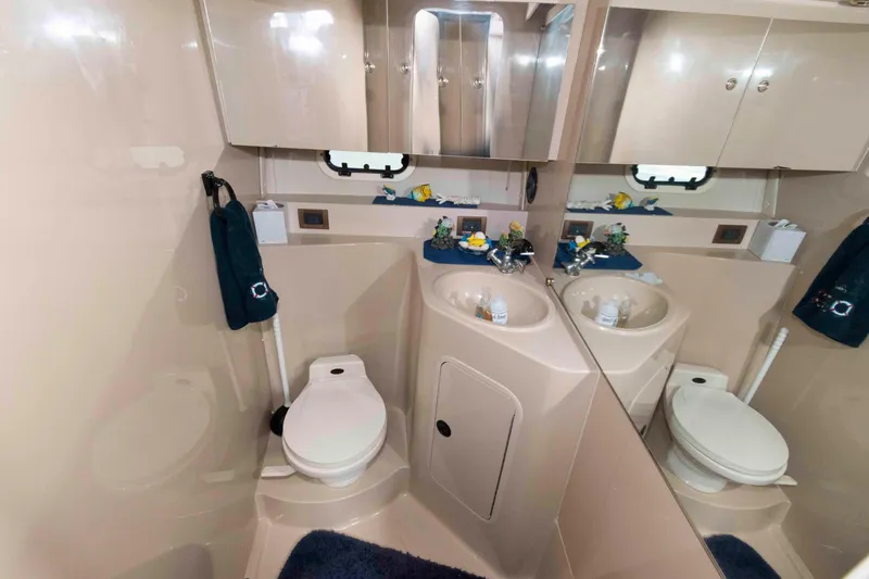 Slide: The Image of 1999 Cruisers Yachts 3750 Motoryacht bathroom with sink, toilet, and mirrored cabinets. - 15