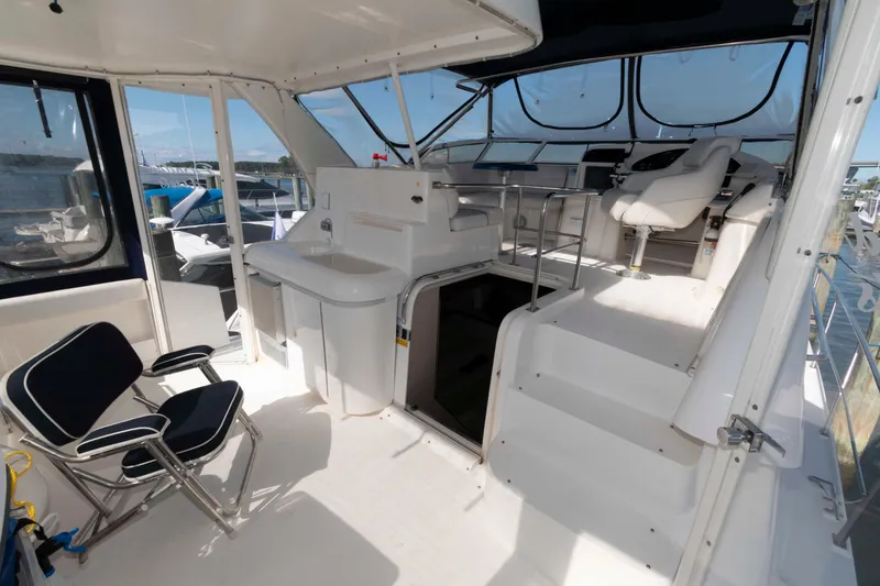 Slide: The Image of 1999 Cruisers Yachts 3750 Motoryacht interior with seating, helm, and sink area. - 2