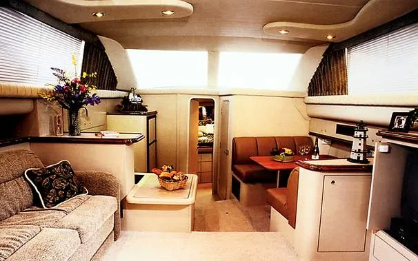 Slide: The Image of 1999 Cruisers Yachts 3750 Motoryacht cockpit with white seating and blue table. - 4