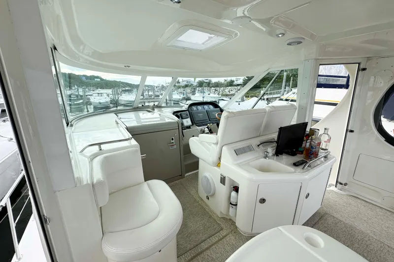 Slide: The Image of 2007 Sea Ray 40 Motor Yacht interior with helm, seating, and bar area in marina setting. - 6