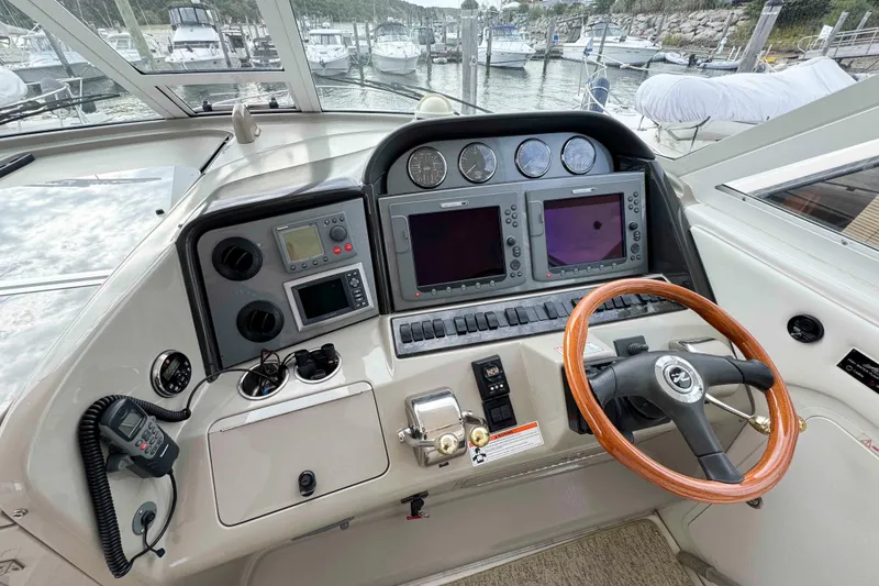 Slide: The Image of 2007 Sea Ray 40 Motor Yacht helm with dual screens and wooden steering wheel. - 7