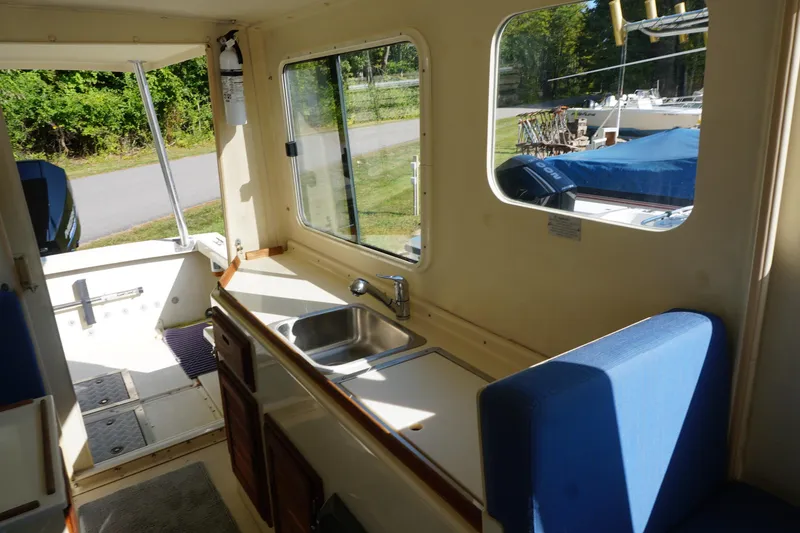 Slide: The Image of 2002 Rosborough RF-246 Sedan Cruiser interior with sink, blue seating, and large windows. - 26