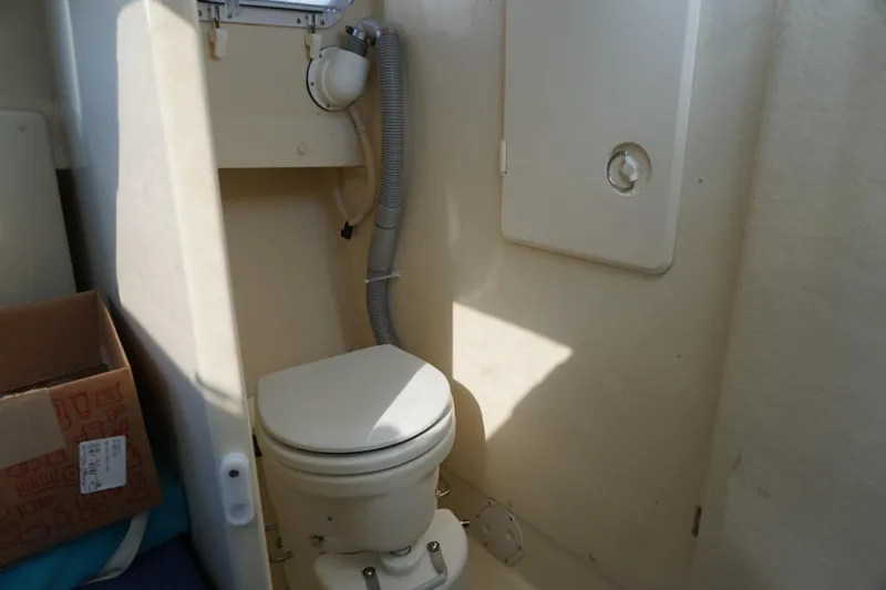 Slide: The Image of 2002 Rosborough RF-246 Sedan Cruiser bathroom with marine toilet and storage compartment. - 28