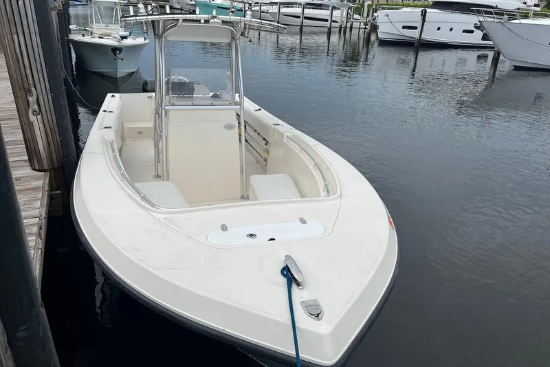 Slide: The Image of 2011 Angler 2600 CC boat docked in a marina, featuring a sleek design. - 3