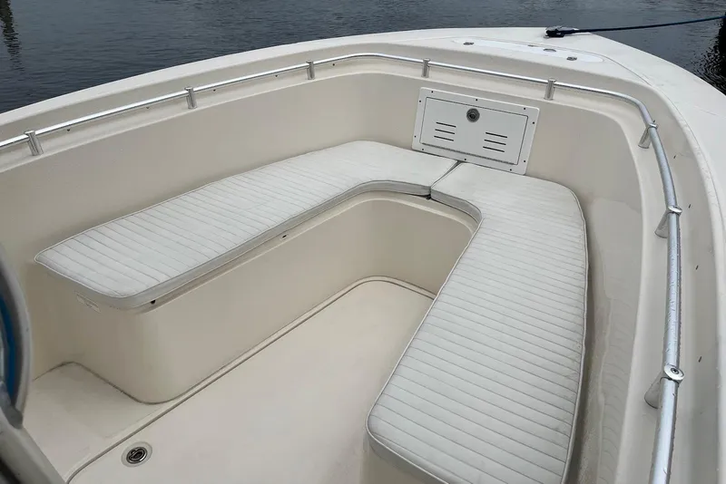Slide: The Image of 2011 Angler 2600 CC boat interior with white cushioned seating and stainless steel railings. - 6