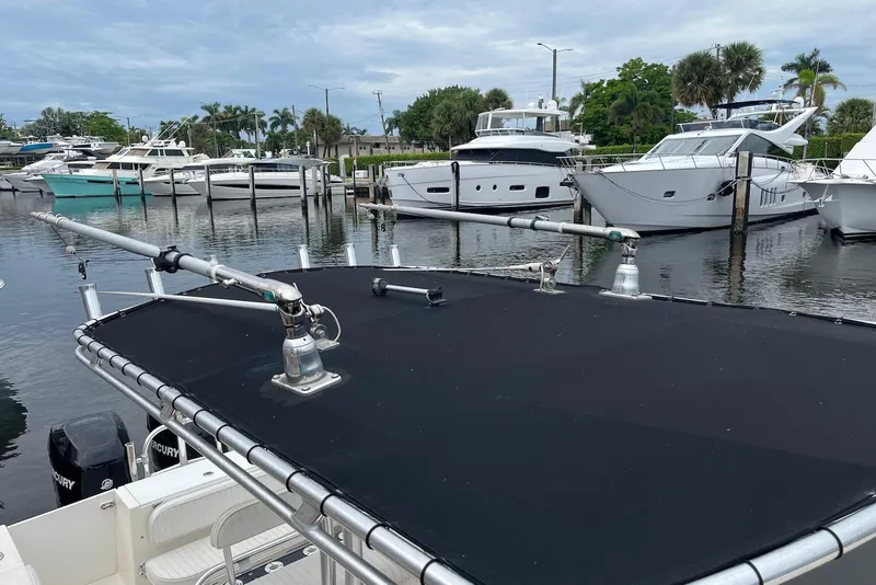 Slide: The Image of 2011 Angler 2600 CC boat with T-top and outriggers docked in marina. - 7