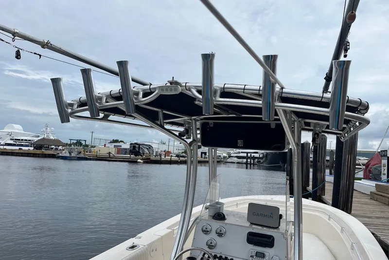 Slide: The Image of 2011 Angler 2600 CC boat with rod holders and Garmin navigation at a marina. - 9