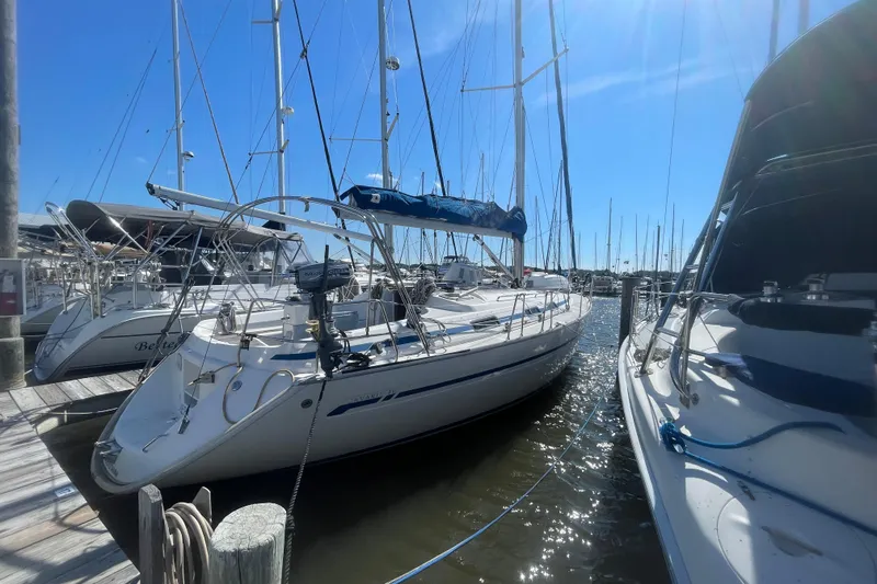 Slide: The Image of Sailboat Bavaria 40, 2002 model, docked at marina under clear blue sky. - 2