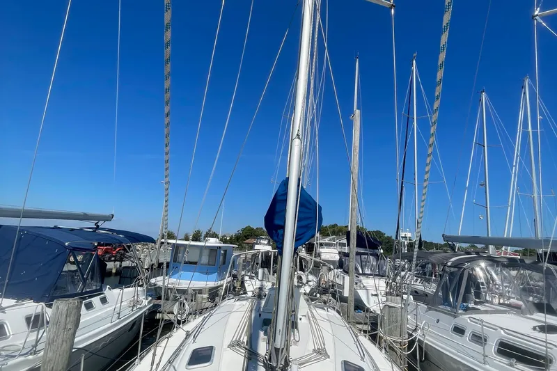Slide: The Image of Sailboats docked at a marina under clear blue skies, featuring a 2002 Bavaria 40. - 3