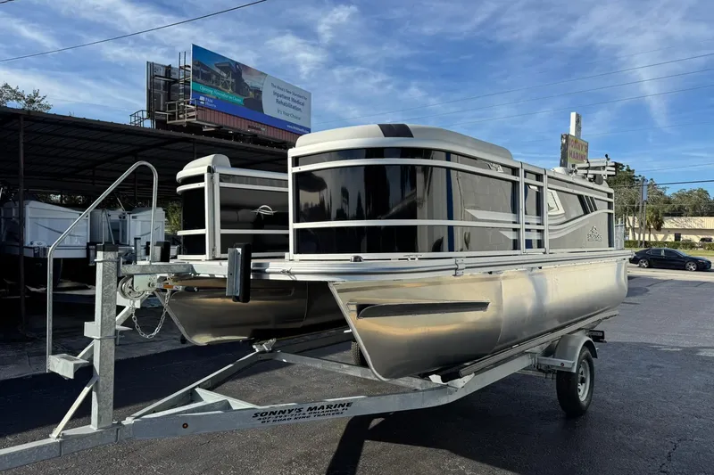 Slide: The Image of 2025 SunCatcher Select 16C pontoon boat on trailer at dealership. - 2