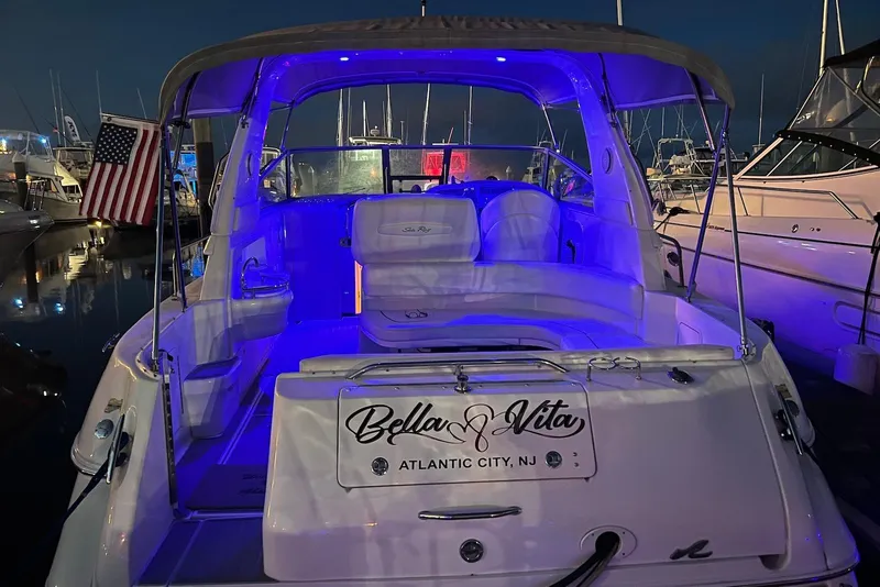 Slide: The Image of 2001 Sea Ray 310 Sundancer yacht with blue interior lighting, docked in Atlantic City marina. - 3