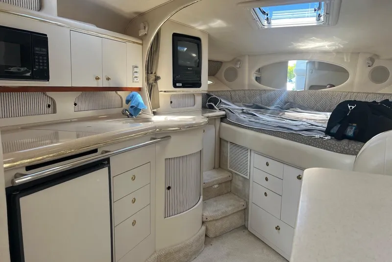 Slide: The Image of 2001 Sea Ray 310 Sundancer cabin interior with kitchenette and sleeping area. - 6