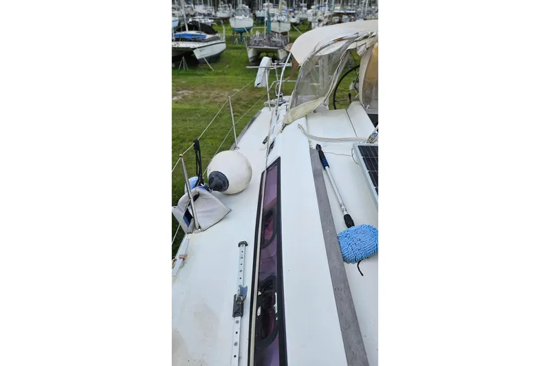 Slide: The Image of 2010 Beneteau Oceanis 34 GT sailboat on land, surrounded by other boats and vehicles. - 35