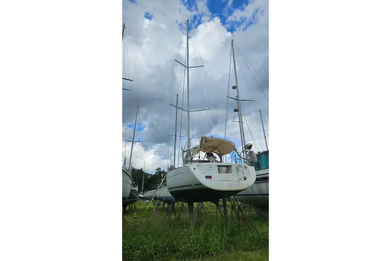 Slide: The Image of 2010 Beneteau Oceanis 34 GT sailboat on stands, with visible hull and red kayak. - 4