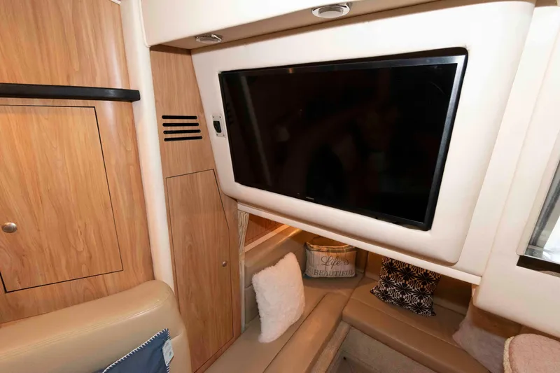 Slide: The Image of 2006 Sea Ray 320 Sundancer cruising on open water with American flag and cushions. - 15