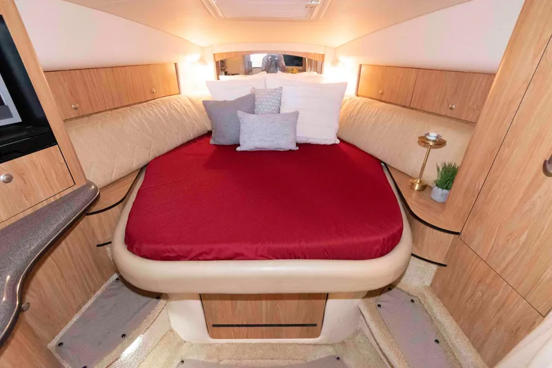 Slide: The Image of Luxurious cabin interior of 2006 Sea Ray 320 Sundancer with red bedding and wooden accents. - 23