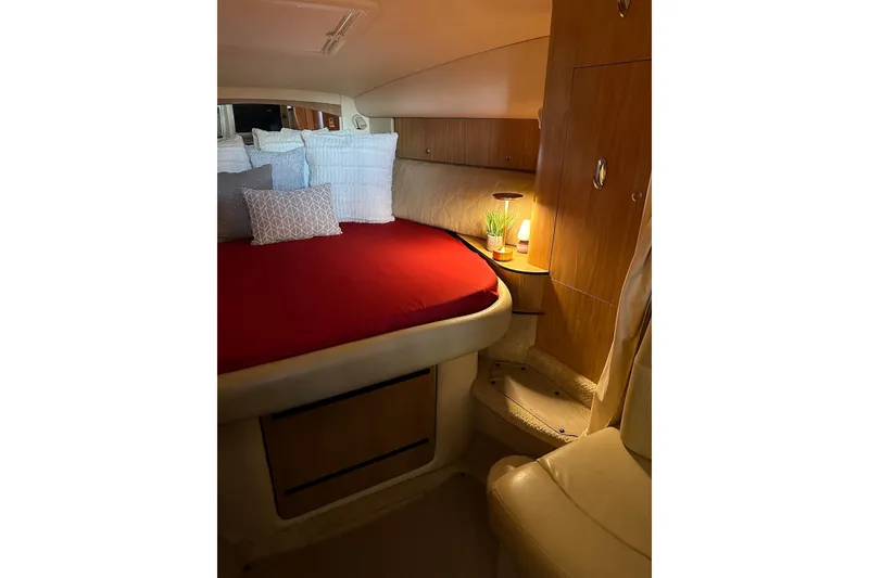 Slide: The Image of Cozy cabin interior of 2006 Sea Ray 320 Sundancer with red bedding and ambient lighting. - 24