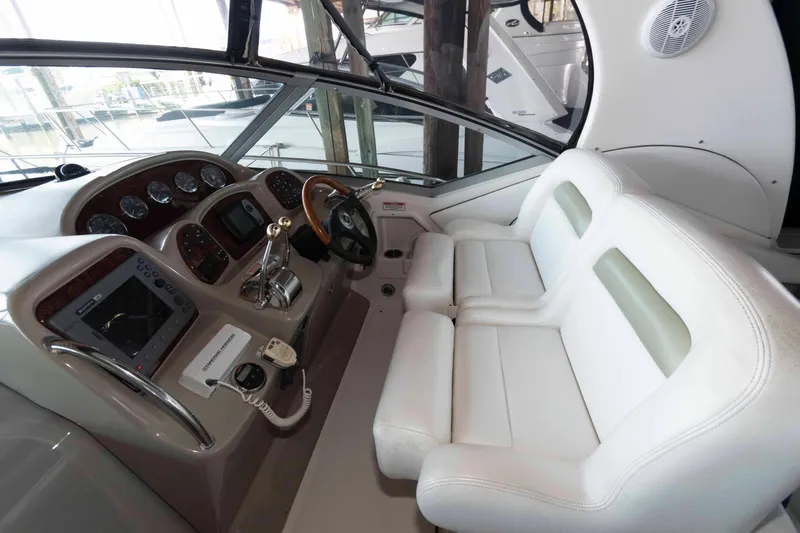 Slide: The Image of 2006 Sea Ray 320 Sundancer boat interior with cushioned seating and decorative pillows. - 5