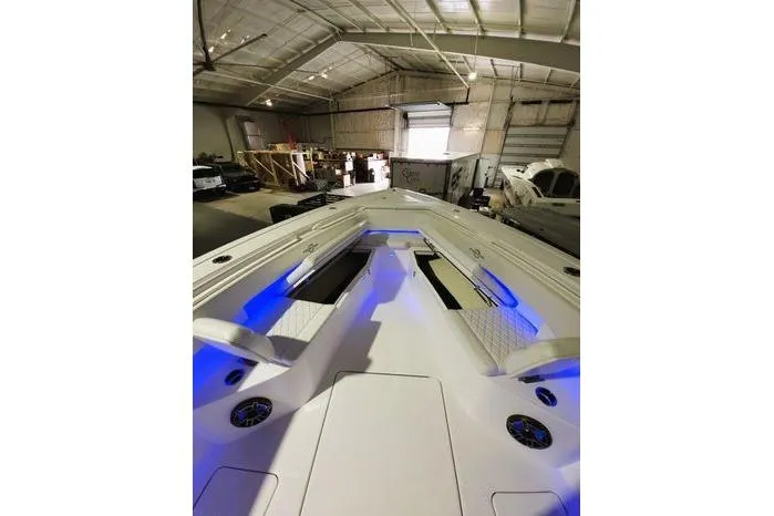 Slide: The Image of 2024 Fountain Bluewater 38 Tournament Edition boat in a warehouse, featuring blue LED lighting. - 12