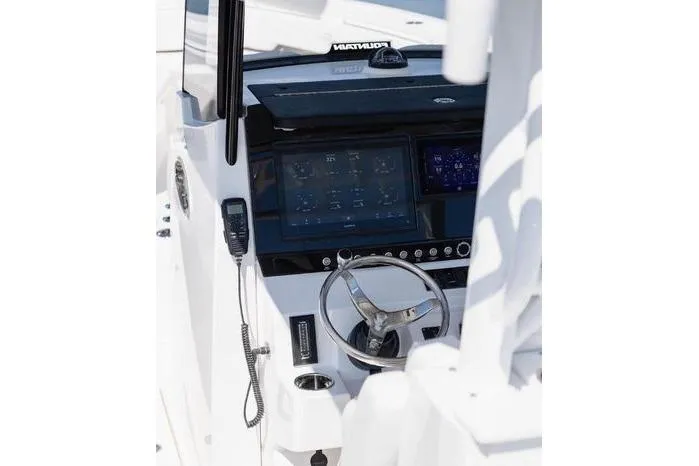 Slide: The Image of 2024 Fountain Bluewater 38 Tournament Edition boat dashboard with steering wheel and navigation screens. - 19