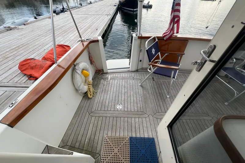 Slide: The Image of 2004 Sabre 36 Hardtop Sedan boat deck with chairs, life preserver, and dock view. - 12