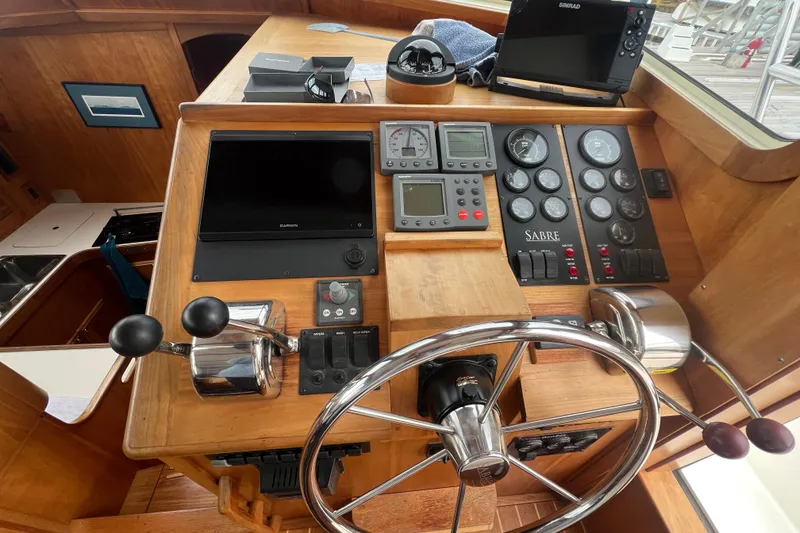 Slide: The Image of 2004 Sabre 36 Hardtop Sedan helm with navigation instruments and wooden finish. - 8