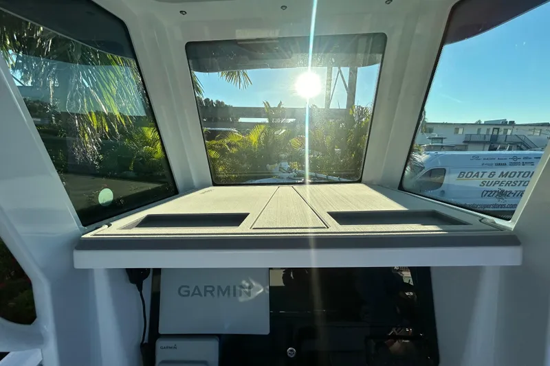 Slide: The Image of Interior view of 2026 Blackfin 242 HB boat with Garmin equipment and sunlit windows. - 12