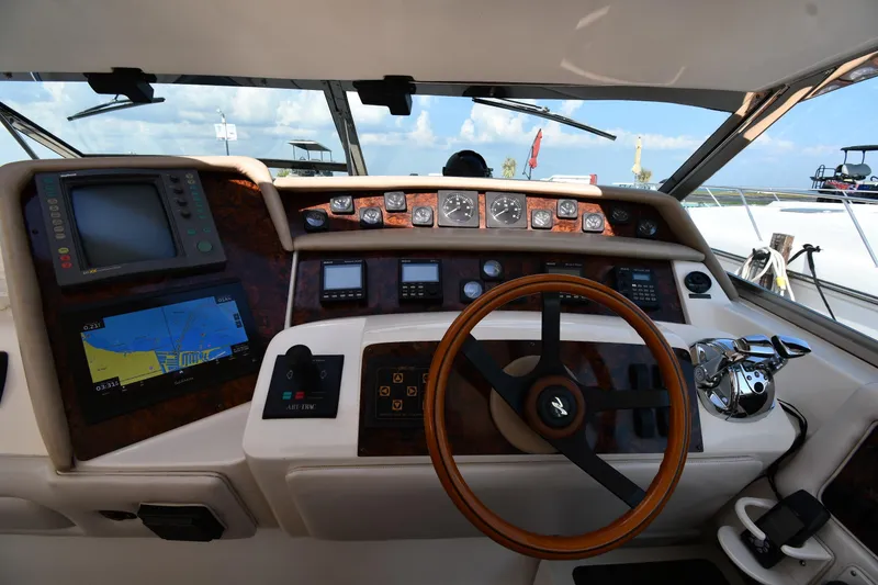 Slide: The Image of 1995 Sea Ray 630 Sundancer helm with navigation equipment and wooden steering wheel. - 12