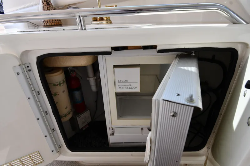 Slide: The Image of 1995 Sea Ray 630 Sundancer yacht interior with open storage compartment and ice maker. - 28