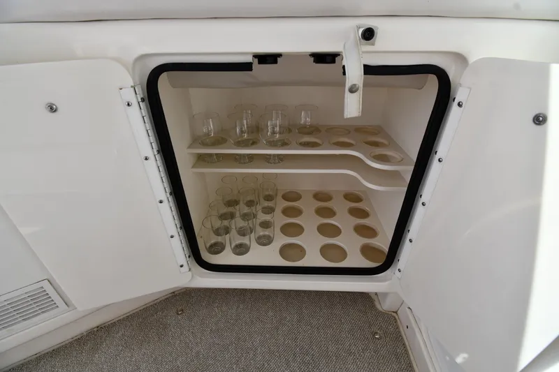 Slide: The Image of Glass storage cabinet on 1995 Sea Ray 630 Sundancer yacht, featuring organized compartments. - 29