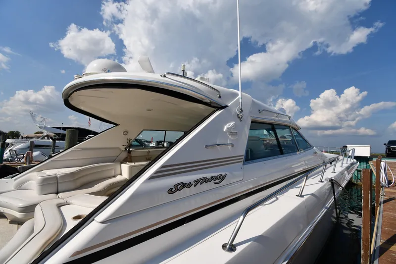 Slide: The Image of 1995 Sea Ray 630 Sundancer yacht docked under a bright blue sky. - 3