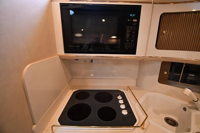 Slide: The Image of Kitchen area of 1995 Sea Ray 630 Sundancer with stove, microwave, and sink. - 57