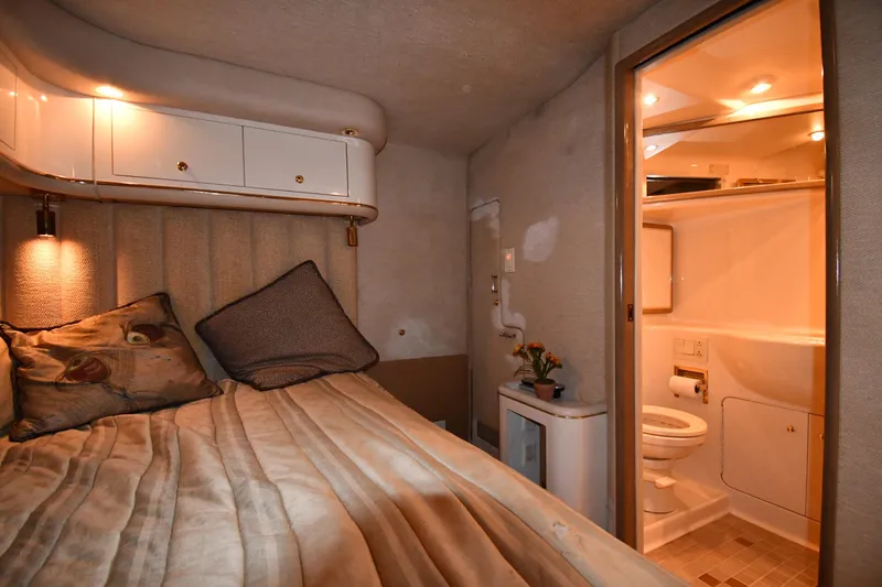Slide: The Image of Cozy cabin interior of 1995 Sea Ray 630 Sundancer with bed and ensuite bathroom. - 65