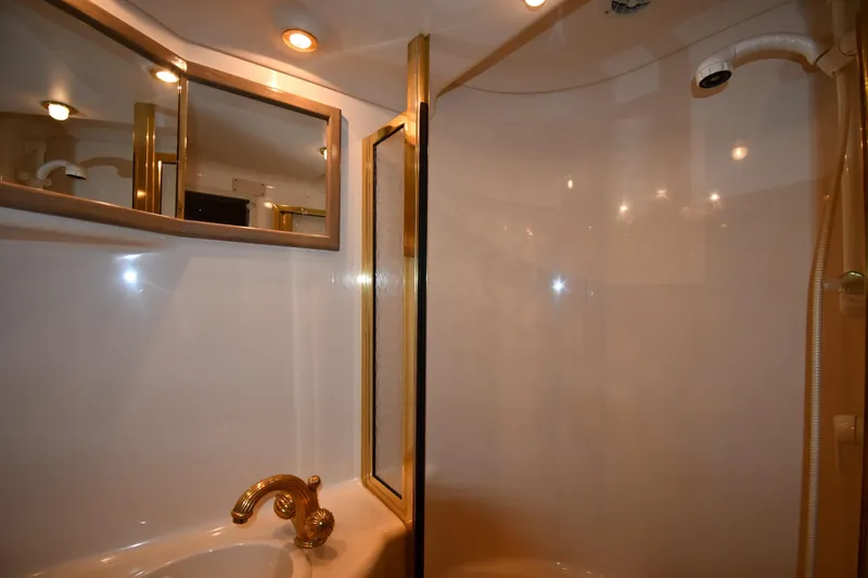 Slide: The Image of Luxurious bathroom interior of 1995 Sea Ray 630 Sundancer yacht with gold fixtures. - 69
