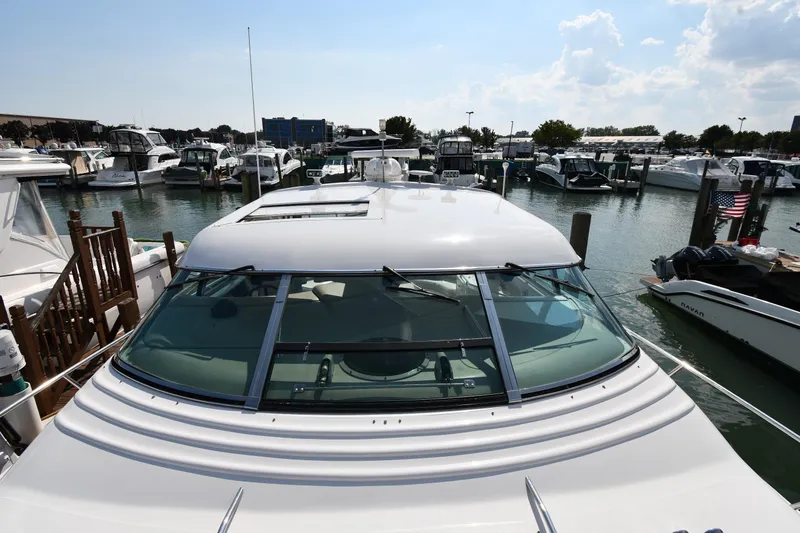 Slide: The Image of 1995 Sea Ray 630 Sundancer docked at a marina, surrounded by other boats. - 8
