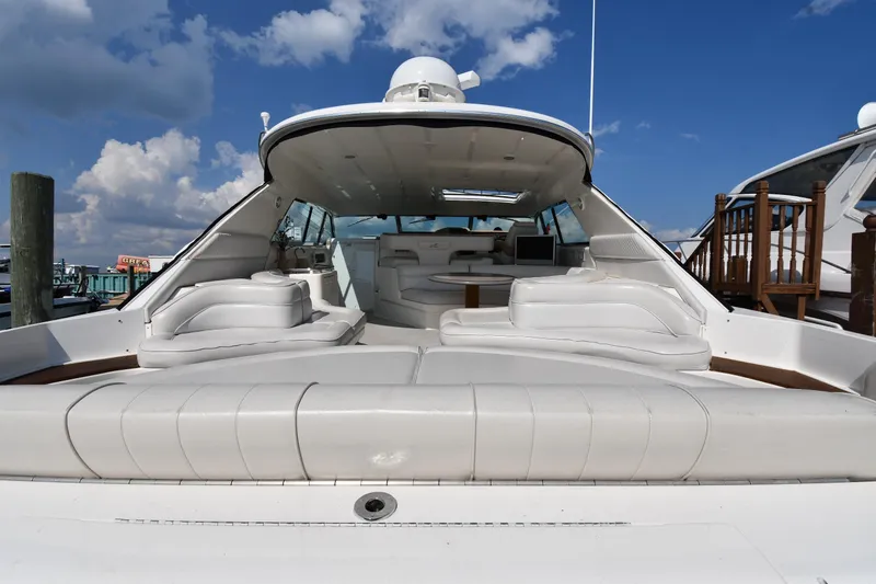 Slide: The Image of 1995 Sea Ray 630 Sundancer yacht with spacious white seating and open deck under blue sky. - 9