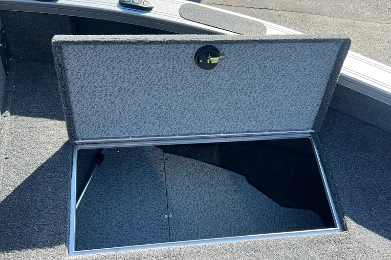 Slide: The Image of Open storage compartment on 2026 Crestliner 2050 Fish Hawk boat, featuring carpeted interior. - 10