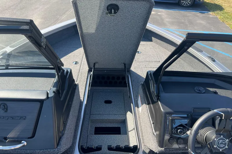 Slide: The Image of 2026 Crestliner 2050 Fish Hawk boat interior with open storage compartment and control panel. - 15