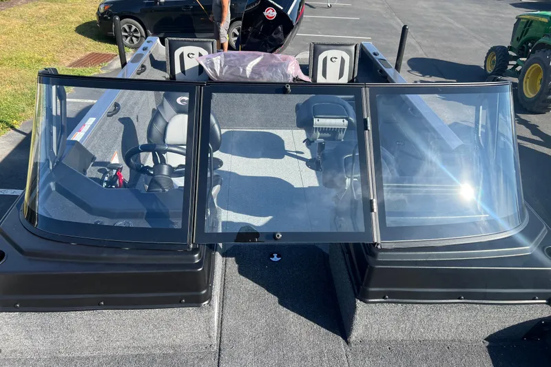 Slide: The Image of 2026 Crestliner 2050 Fish Hawk boat with windshield and seating, parked outdoors. - 17