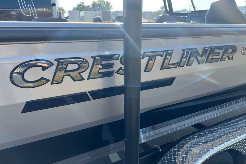 Slide: The Image of 2026 Crestliner 2050 Fish Hawk boat side view with logo in sunlight. - 2