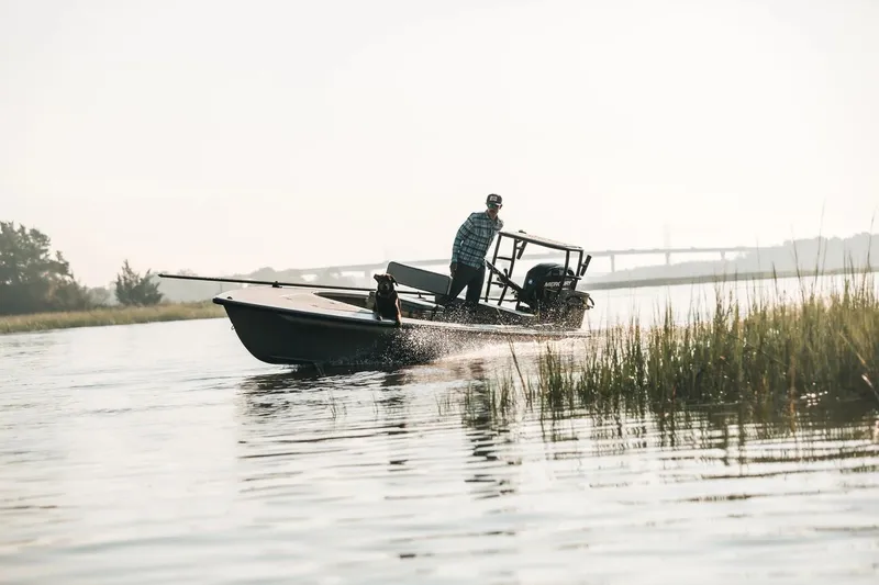 Slide: The Image of Man navigating Delta Boatworks D-18, 2026 model, through marshy waters. - 7