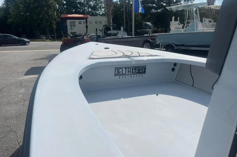 Slide: The Image of 2026 Delta Boatworks D18 with outboard motor, parked outdoors in a lot. - 3