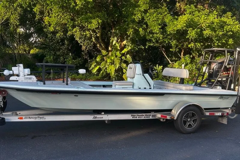 The Image of 2019 Maverick 18 HPX-V boat on trailer, parked outdoors with lush greenery background. - 0