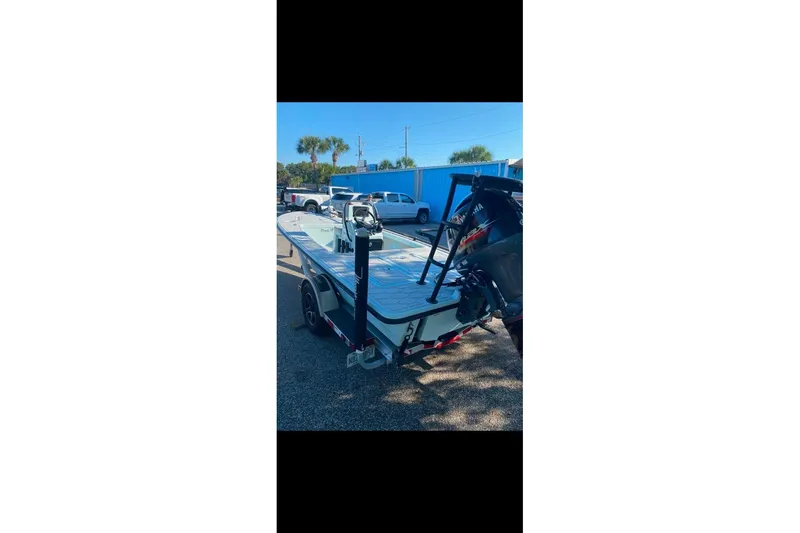 Slide: The Image of 2019 Maverick 18 HPX-V boat on trailer, parked outdoors under clear sky. - 2
