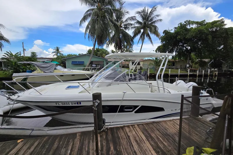 The Image of 2020 Jeanneau Leader 9.0 WA boat docked near palm trees and waterfront homes. - 0