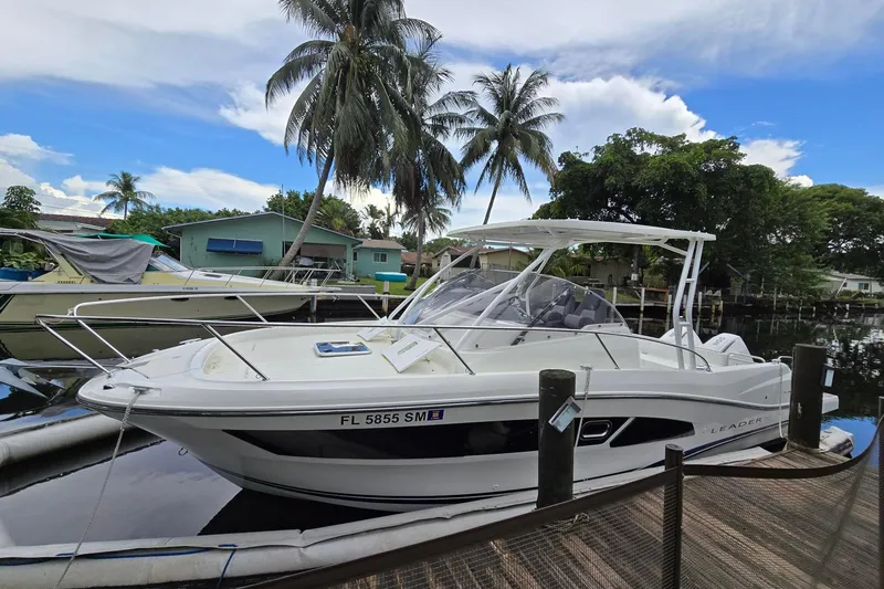 Slide: The Image of 2020 Jeanneau Leader 9.0 WA boat docked near palm trees and waterfront homes. - 1
