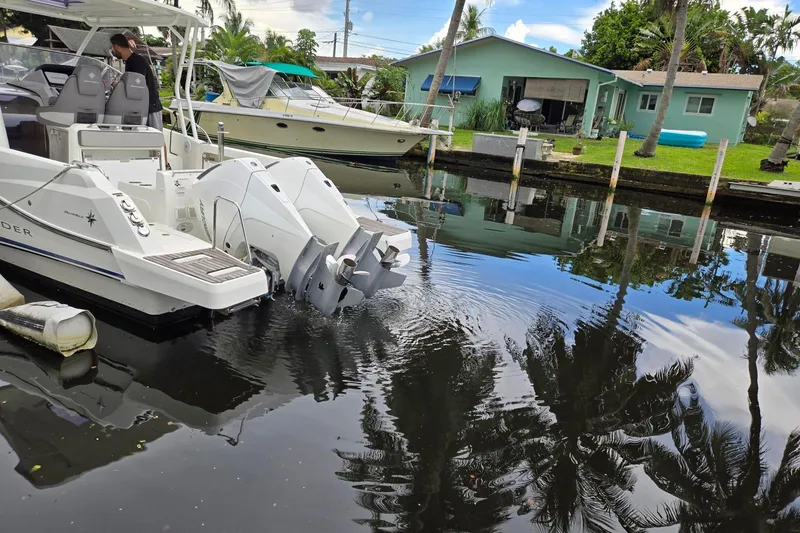 Slide: The Image of 2020 Jeanneau Leader 9.0 WA boat docked in a canal, reflecting palm trees and houses. - 5