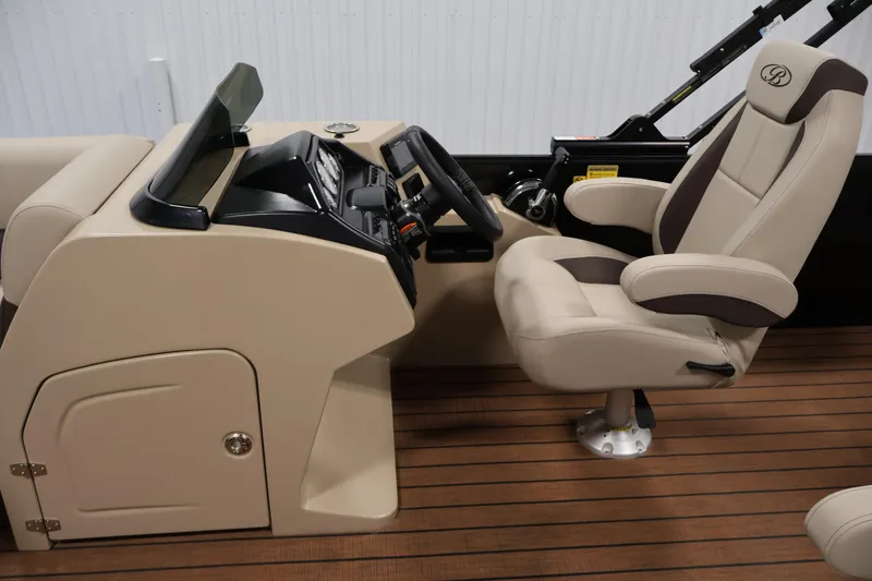 Slide: The Image of 2026 Bentley Pontoons 243 Swingback Tri-toon helm with beige captain's chair and dashboard. - 17