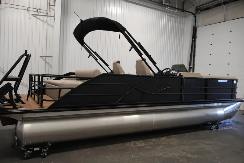 Slide: The Image of 2026 Bentley Pontoons 243 Swingback Tri-toon in a showroom, featuring sleek black design. - 3